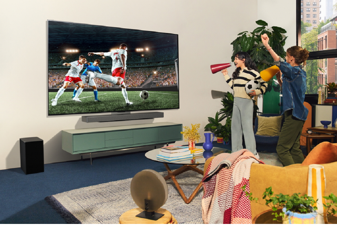 An image of two women celebrating while watching the television screen
