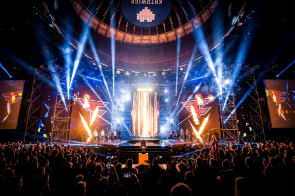 A picture of the stage with lights and fireworks with players on stage