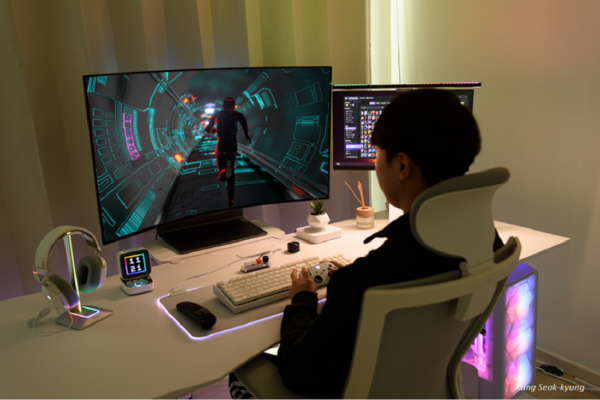 An image of a person sitting at the desk with the LG OLED Flex in front