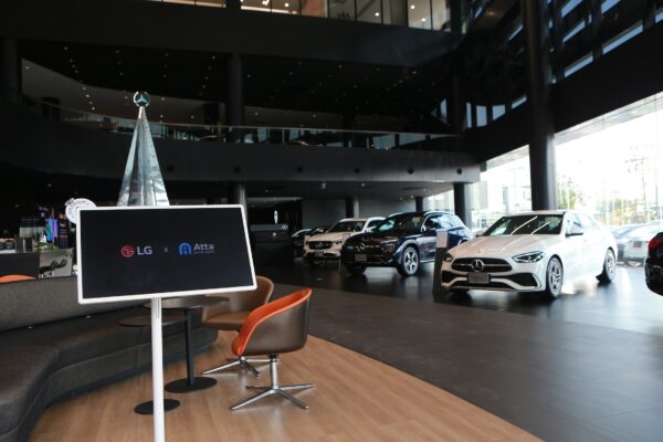 A picture of Mercedes Benz vehicles lined up in the showroom with an LG screen near it