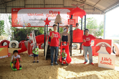 A picture of two men and children standing infront of the Life's Good playground