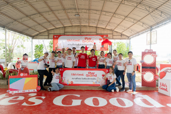 A picture of a group of people gathered around at the venue holding LG logo signs