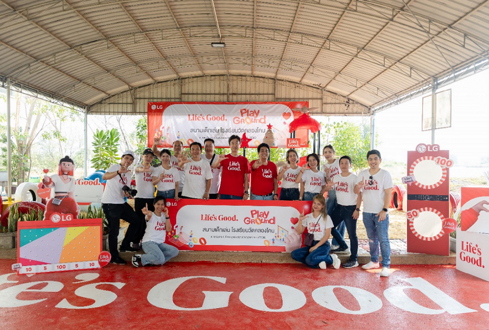 An image of a group of people gathered around at the venue holding LG logo signs