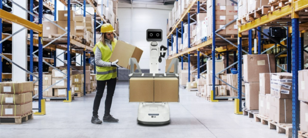 A picture of a woman placing boxes on a LG CLOi bot at a warehouse