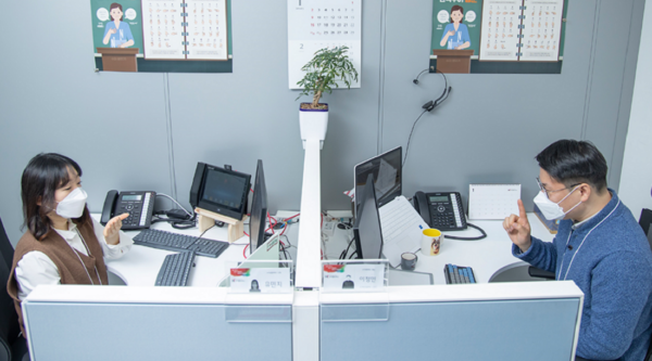 A picture of two people sitting a their desk and doing services