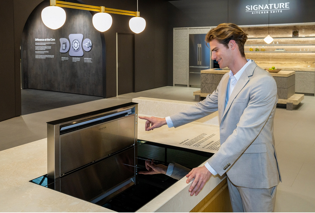 Image of a man experiencing a free zone induction hob in the SIGNATURE KITCHEN SUITE Kitchen zone at Salone del Mobile