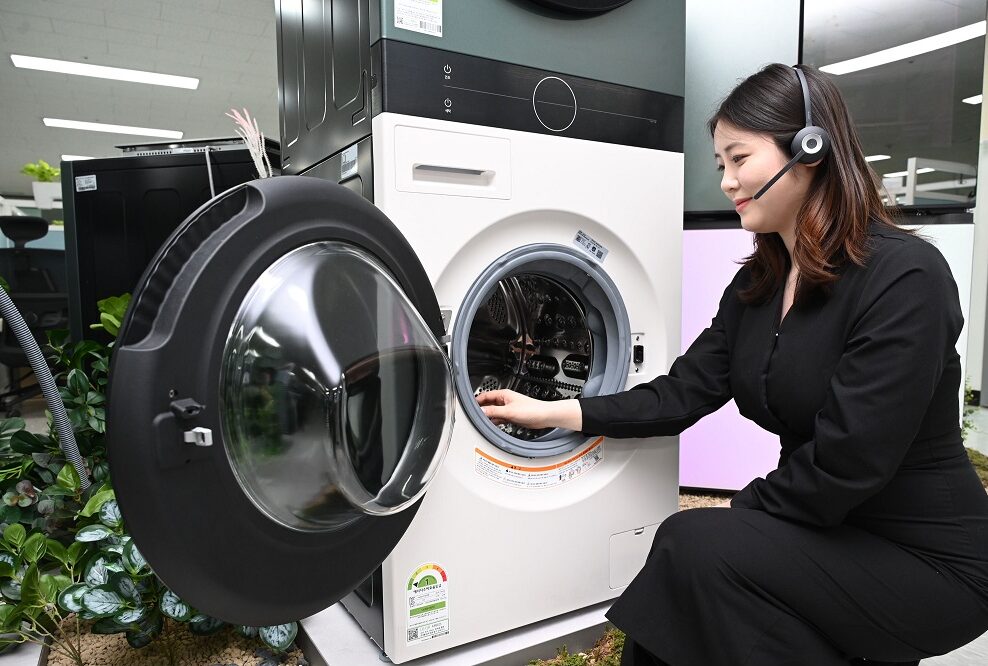 Woman with headphones on sitting next to a washer
