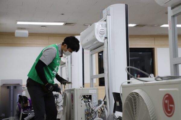 A picture of a man fixing an LG air conditioner