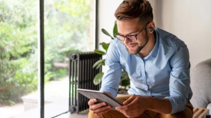 A man is viewing content on his tablet with T90S earbuds plugged in his ears
