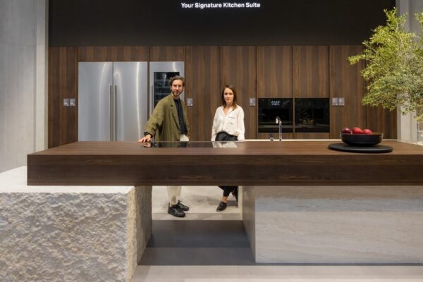 A man and a woman standing at the signature kitchen suite display area