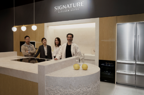 A photo of four people standing near the kitchen display area