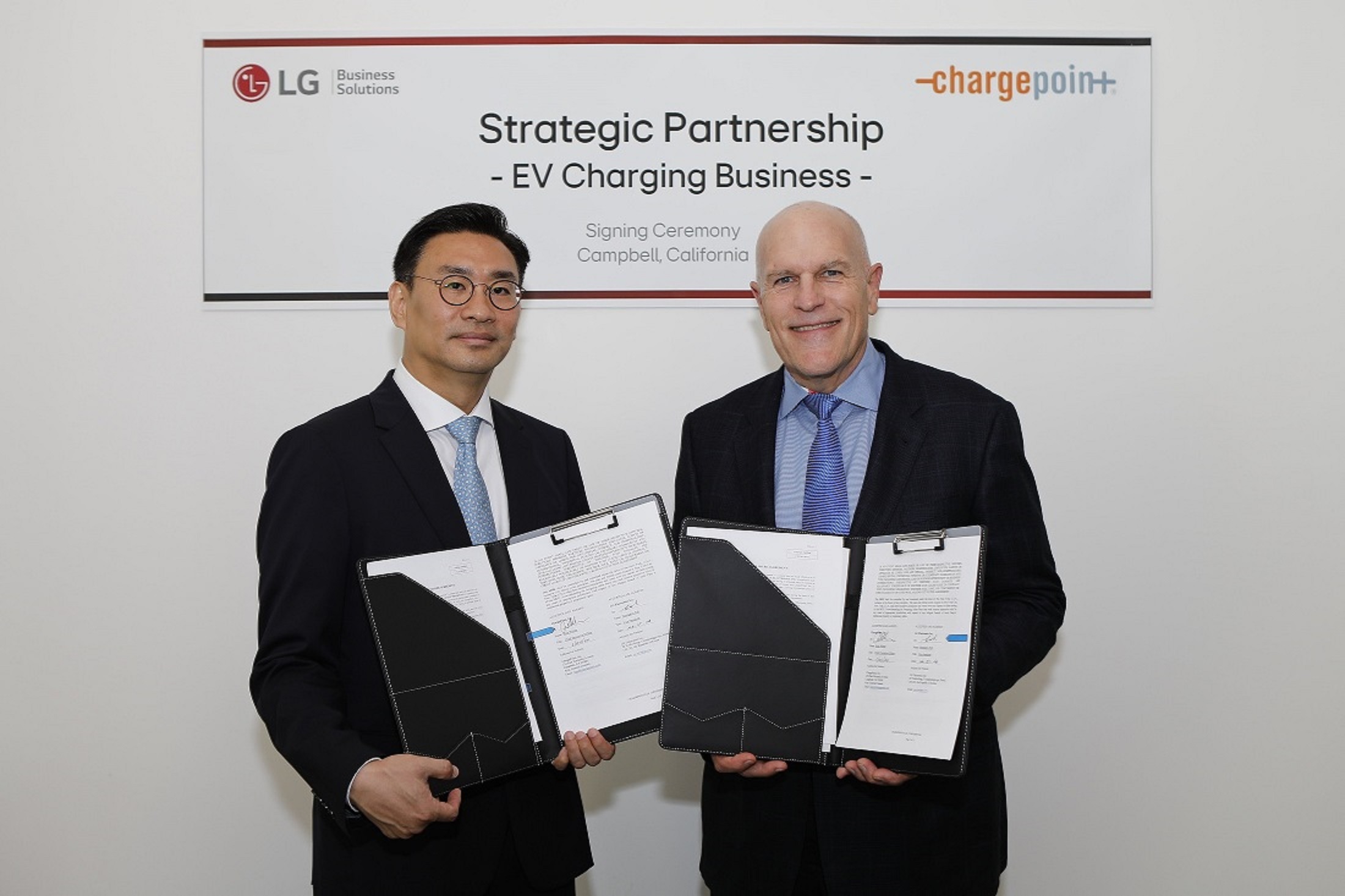 A picture of LG Electronics (left) and ChargePoint (right) representatives each holding signed MOU documents