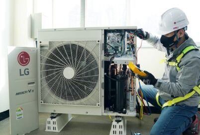 A photo of service technician looking into the outdoor unit