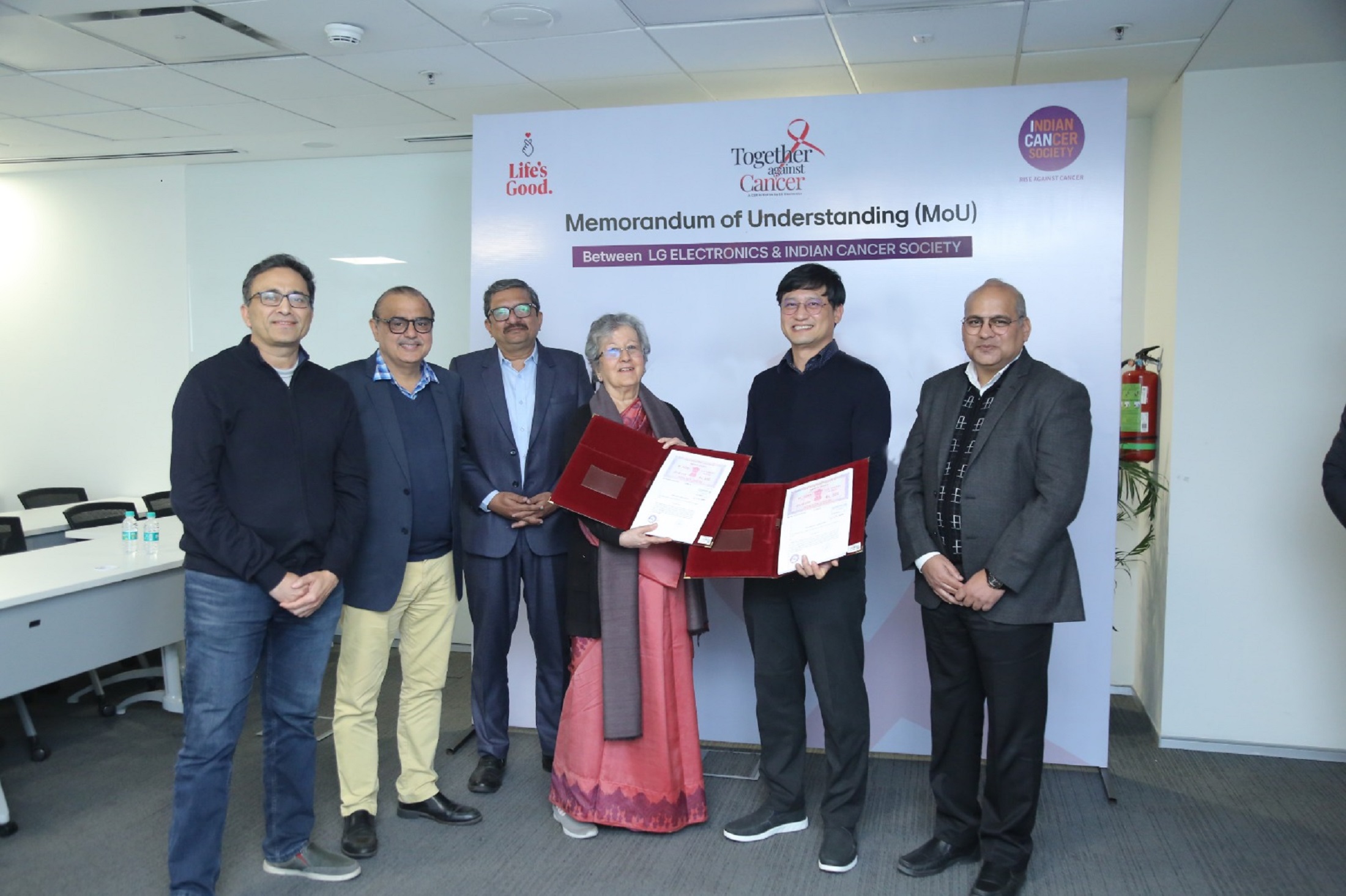 A picture of six people standing for a photo regarding the MOU