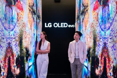 A man and a woman taking a photo in the background of the screen at multi-sensory experience space