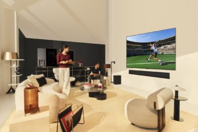 A picture of a woman and a man in a living room watching sports on the OLED TV