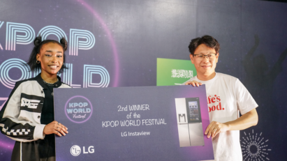 A picture of the 2nd winner posing on stage with an LG employee