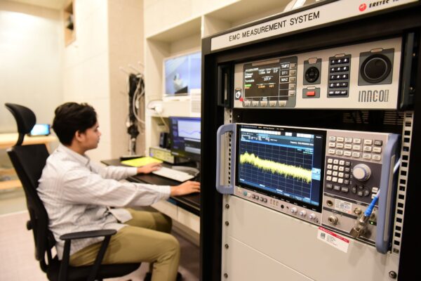 A picture of man on the computer with measurement systems next to him
