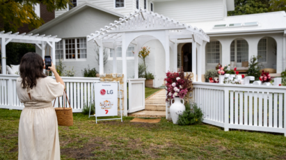 A picture of a woman taking a picture of the contestant's home at the event