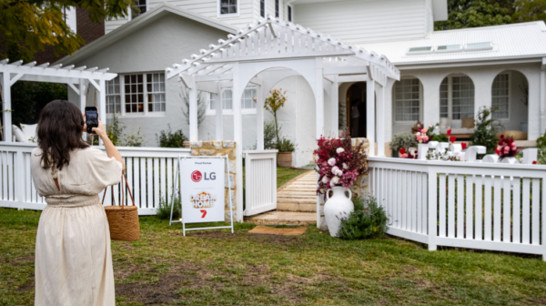 A picture of a woman taking a picture of the contestant's home at the event