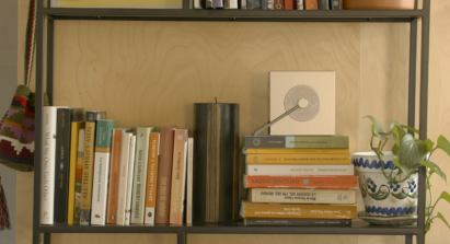 LG CineBeam Q projector as an objet, placed on a bookshelf among books