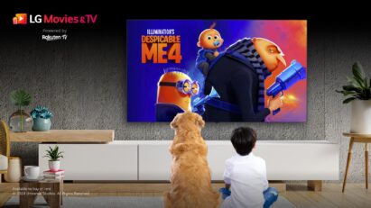 A child and a dog sit on a living room floor, captivated by Despicable Me 4 on a wall-mounted LG TV
