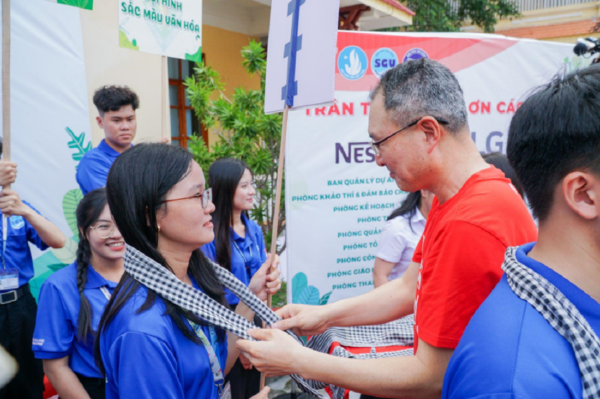 A picture of a man helping a student from the Green Summer 2024 Campaign
