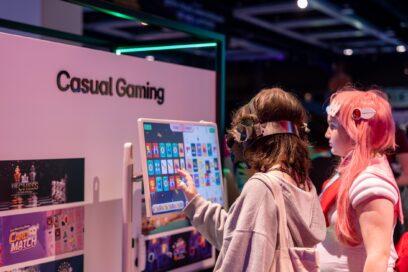 Two visitors are browsing through games on a touch screen in the LG Casual Gaming Zone