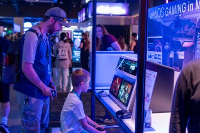 A man and a boy are playing games on an LG lifestyle device using a controller pad