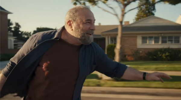 A picture of a man riding a skateboard down the road