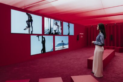 A woman observes the artwork by John Akomfrah, displayed on LG OLED TVs