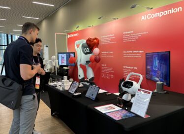 A picture of two people looking at the AI Agent at the booth