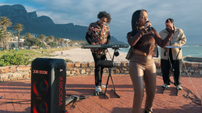 Three South African artists perform in front of a beach, with an LG XBOOM speaker