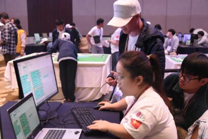 A picture of contestants using the computer together