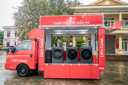 A photo of a red truck with the LG logo fully equipped with washers and dryers