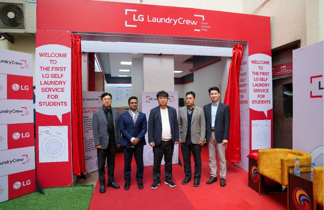 A photo of five men standing and smiling in front of the LG Laundry Crew event