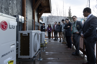 A photo of Getu Hailu (Professor of Associate Professor of UAA), Sangok Kweon (Director of LG Electronics research and development), and Kenrick Mock (Dean of the College of Engineering of UAA) discussing in front of the LG heat pump solutions