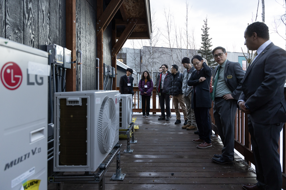 A photo of Getu Hailu (Professor of Associate Professor of UAA), Sangok Kweon (Director of LG Electronics research and development), and Kenrick Mock (Dean of the College of Engineering of UAA) discussing in front of the LG heat pump solutions