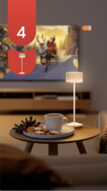 An illustration of a living room with a TV, coffee and cookies in front of a table, and table lights