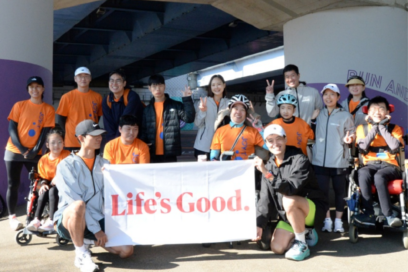 A photo of participants in the 2024 JTBC Seoul Marathon and LG employees smiling with the Life's Good banner