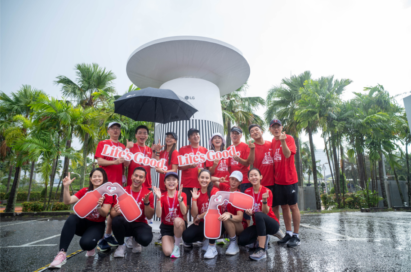 A photo of people smiling in front of a large outdoor LG product mockup