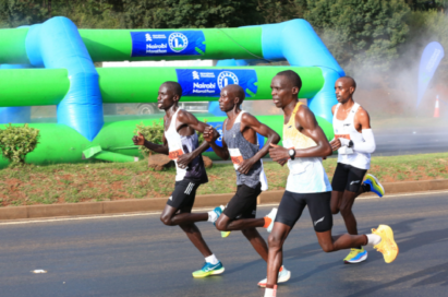 A photo of four participants in a marathon, running hard