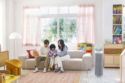 A photo of the LG PuriCare AeroBooster set up in a living room beside a family