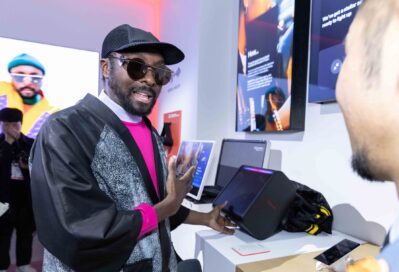 A photo of will.i.am browsing audio products at the xboom booth