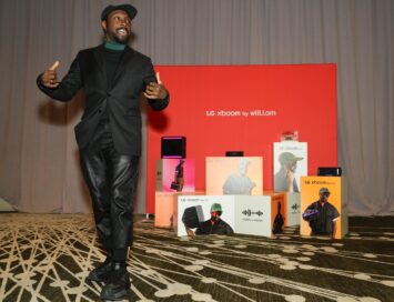 A photo of the 2025 LG xboom by will.i.am lineup on display and will.i.am standing and talking in front of it