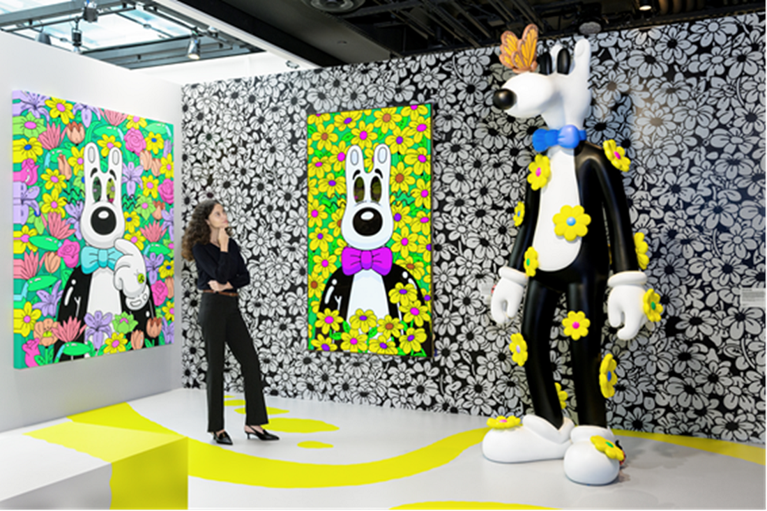 A photo of a woman looking at a sculpture of the character featured in the artwork